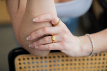 Load image into Gallery viewer, Close-up of two hands with gold rings on a blurred background
