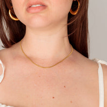 Load image into Gallery viewer, Woman wearing a gold necklace and hoop earrings against a plain background
