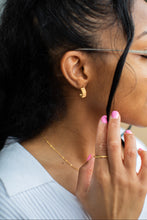 Load image into Gallery viewer, Woman wearing glasses with a close-up of her face and hand.
