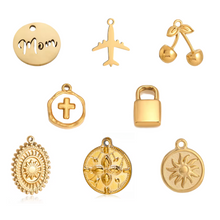 Load image into Gallery viewer, Collection of gold pendants on a white background 
